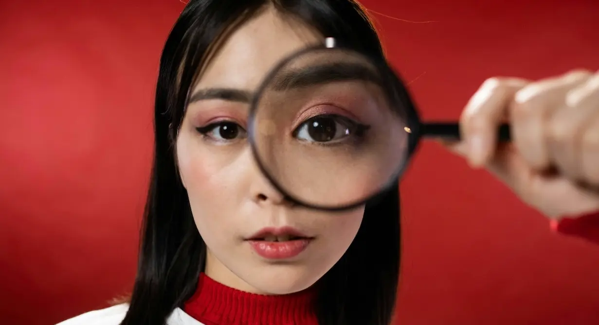 Woman with a magnifying glass looking for a way to get free of her small business