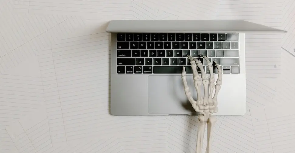 A stuck, tired and stretched business owner using the keyboard of their laptop